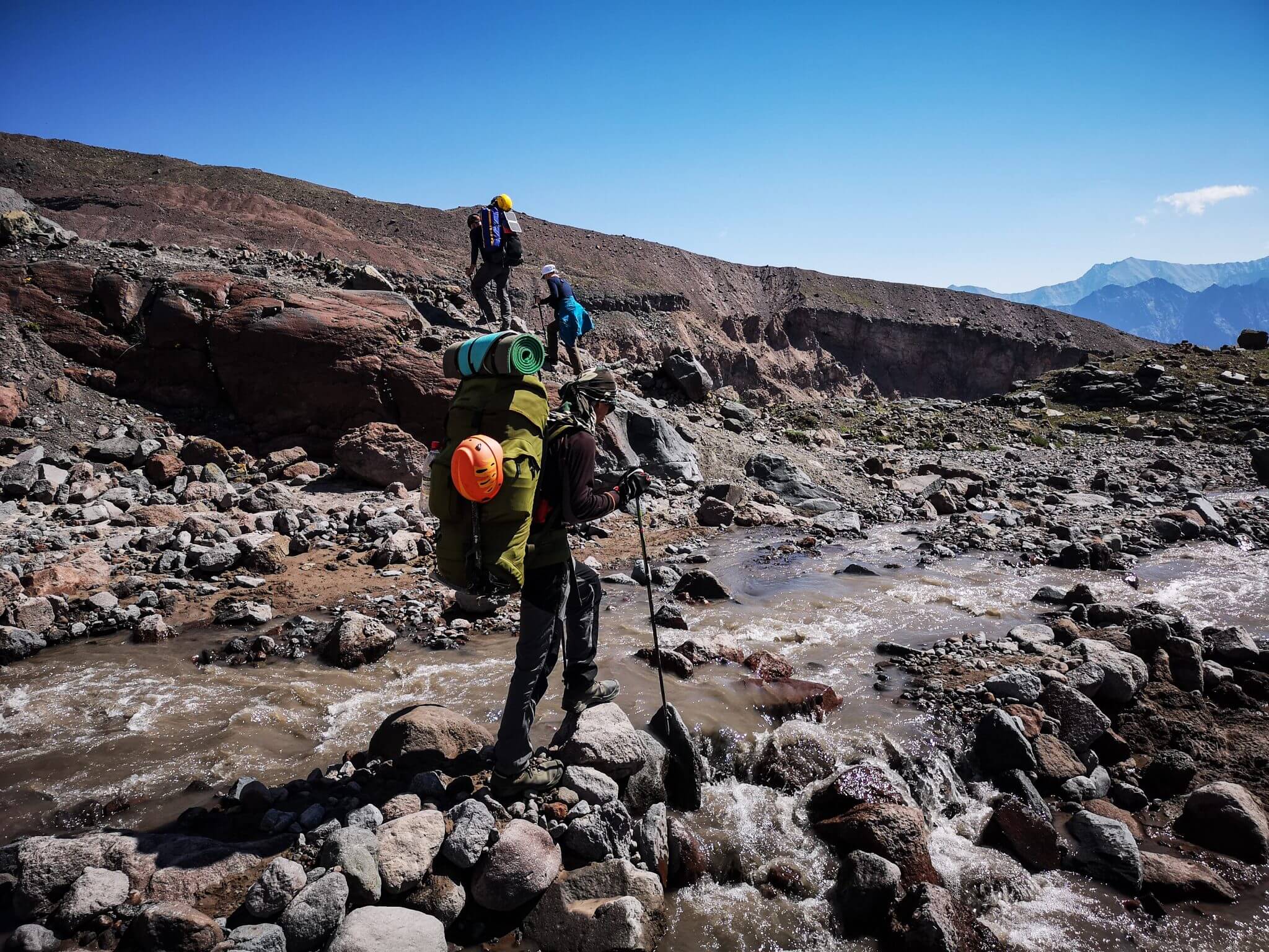mountaineer crossing mountain creek
