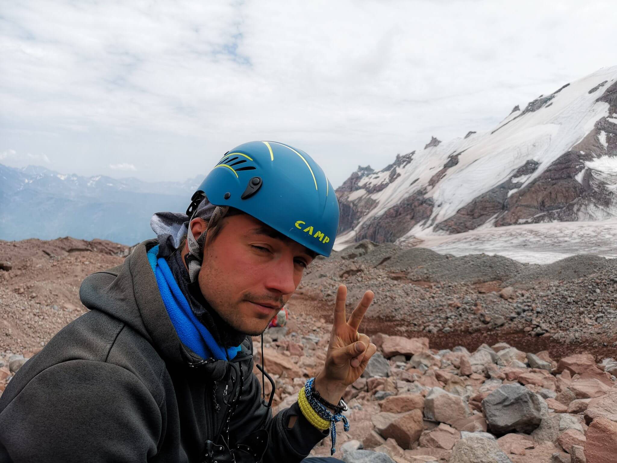 exhausted mountain climber showing victory sign
