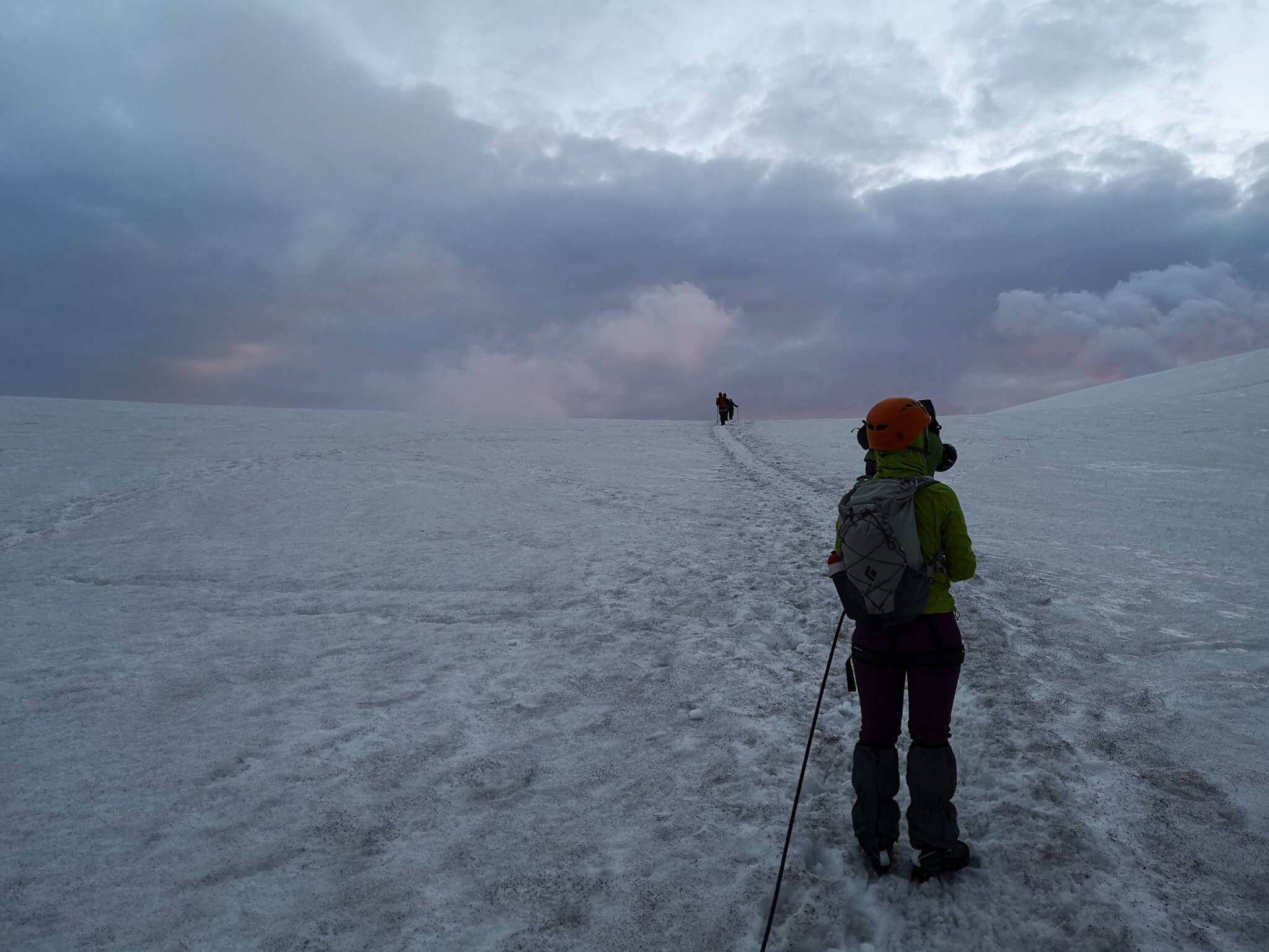 mountain climber walking toward clouds