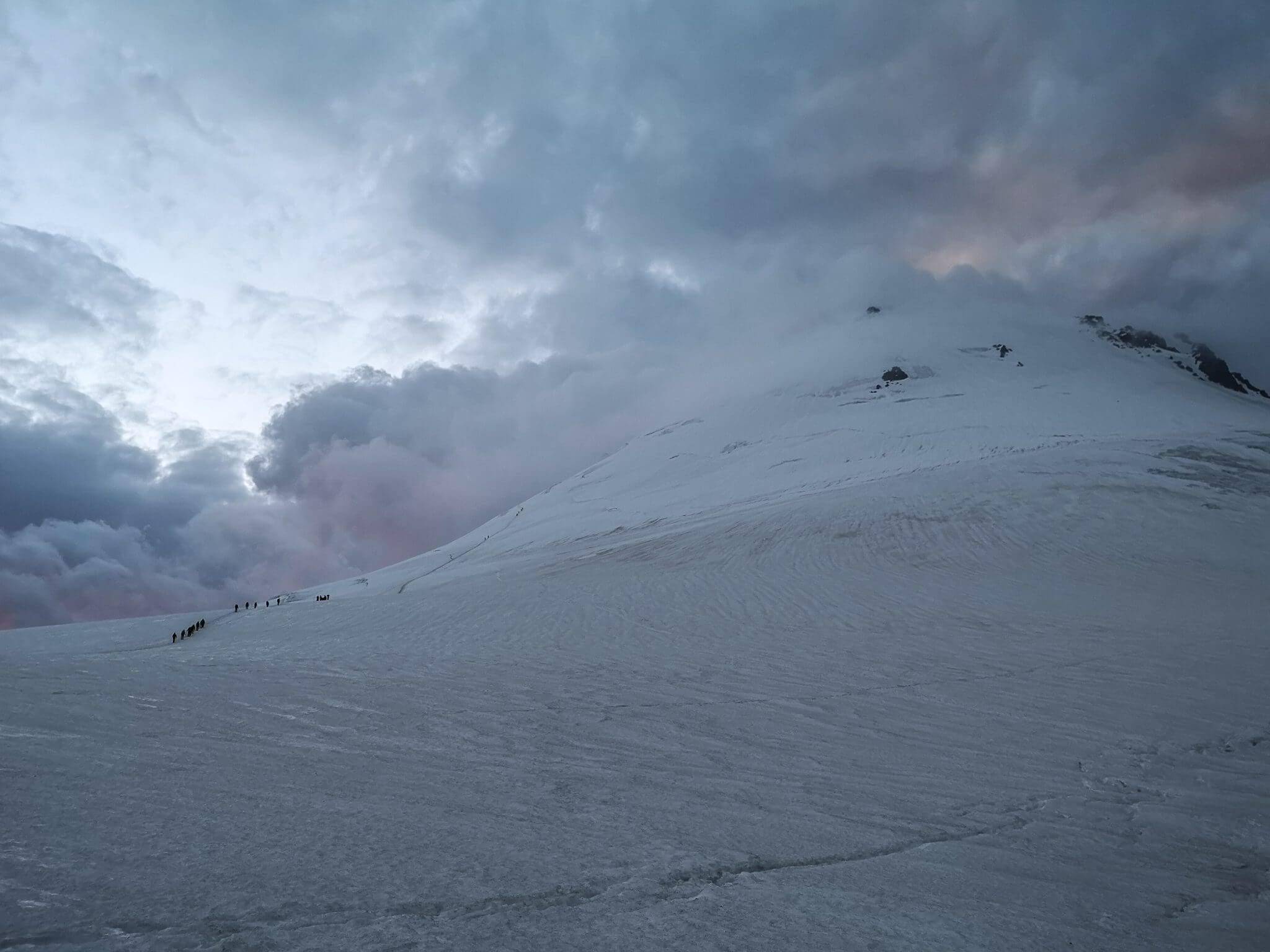 mountaineers climbing a mountain covered by clouds