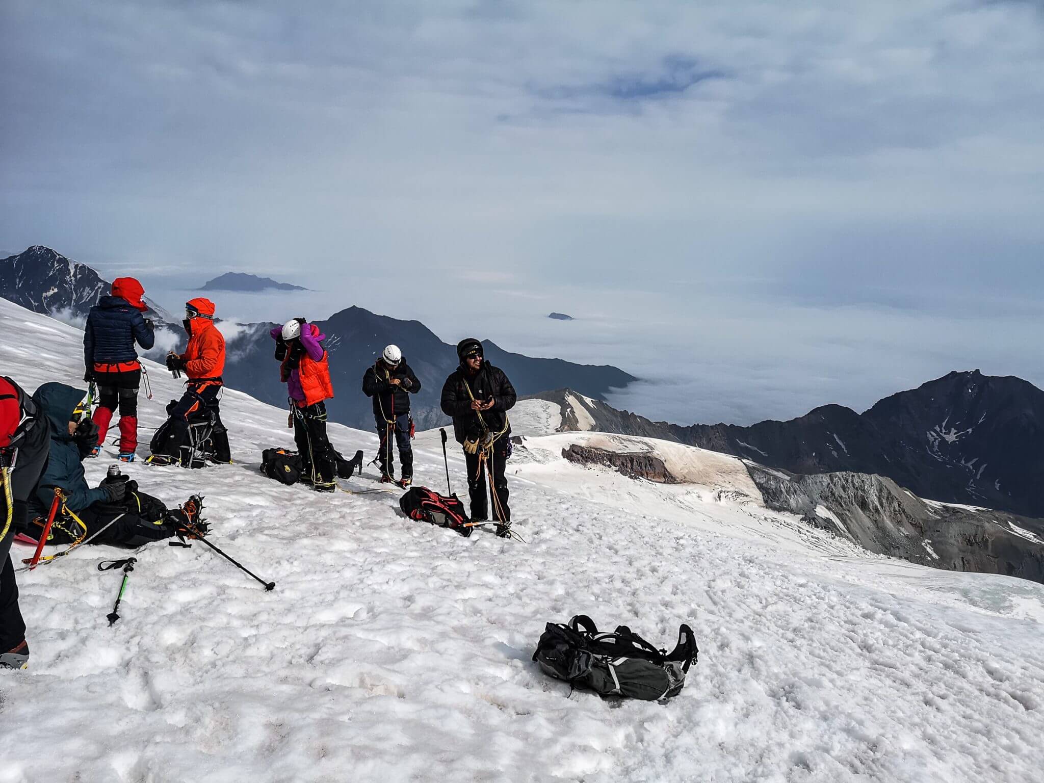 mountaineers resting on the top of mount kazbek
