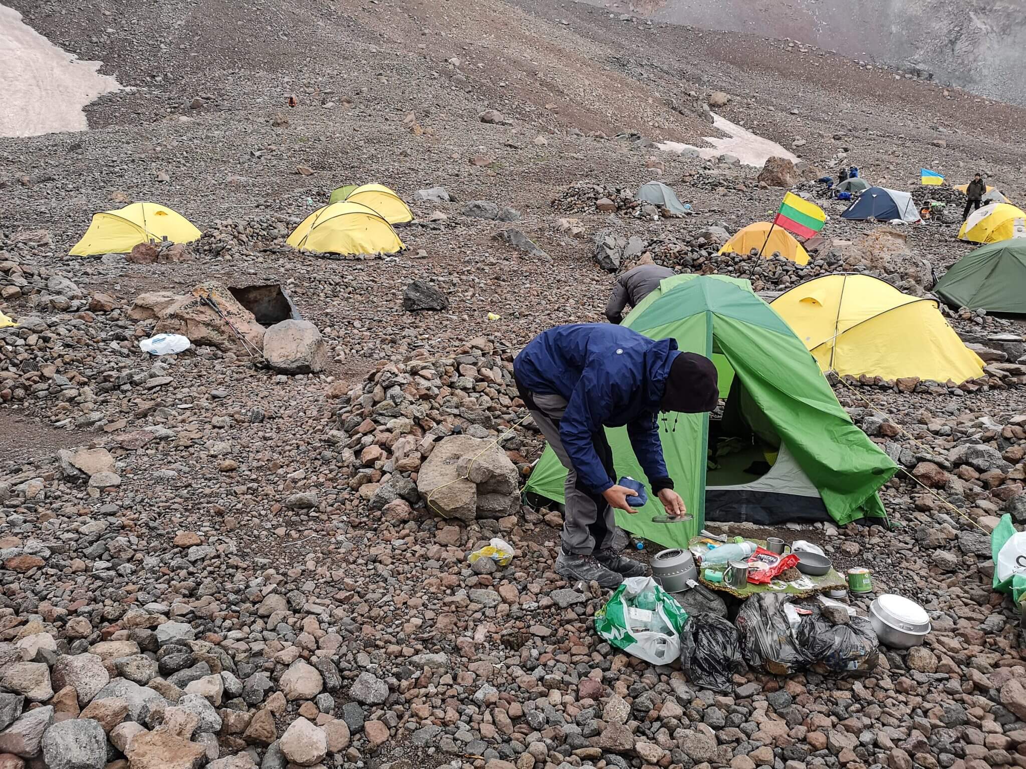 climber cleaning mess near tent