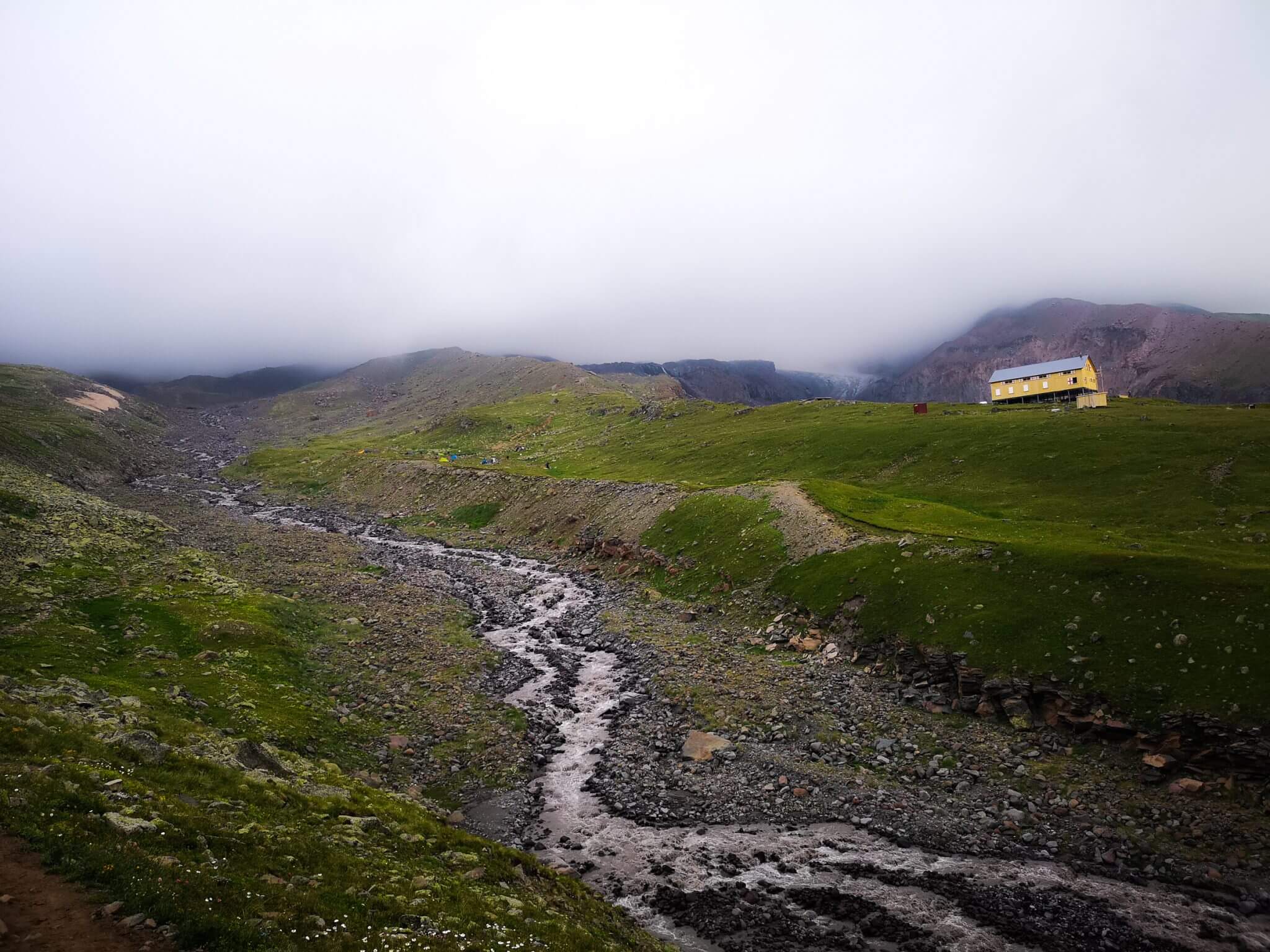 mountain hut clouds grass