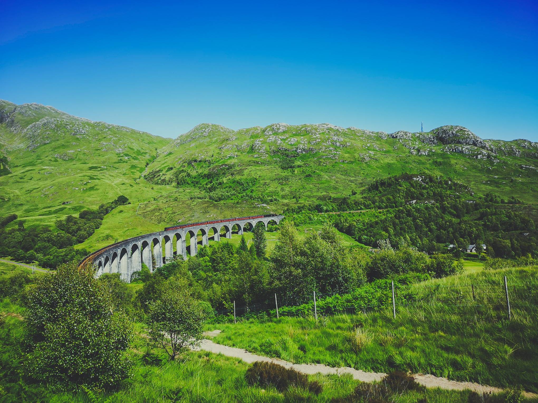   The Jacobite train on Glenfinnan Viaduct from Mallaig could be seen 15 minutes after the one rolling from Fort WIlliam. Photo by Alis Monte [CC BY-SA 4.0], via Connecting the Dots