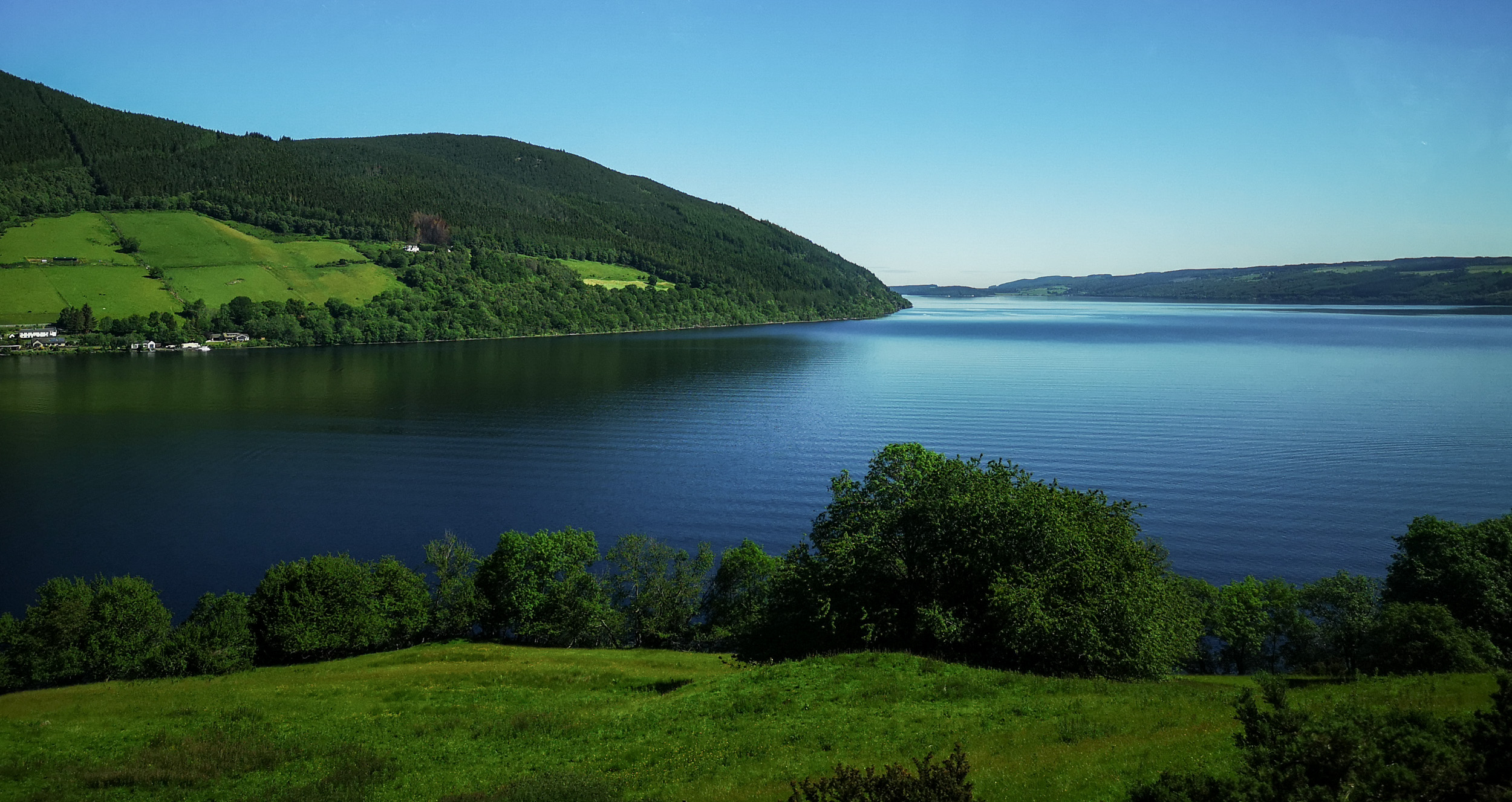 Loch Ness surounded by hills on a sunny day, Highlands of Scotland