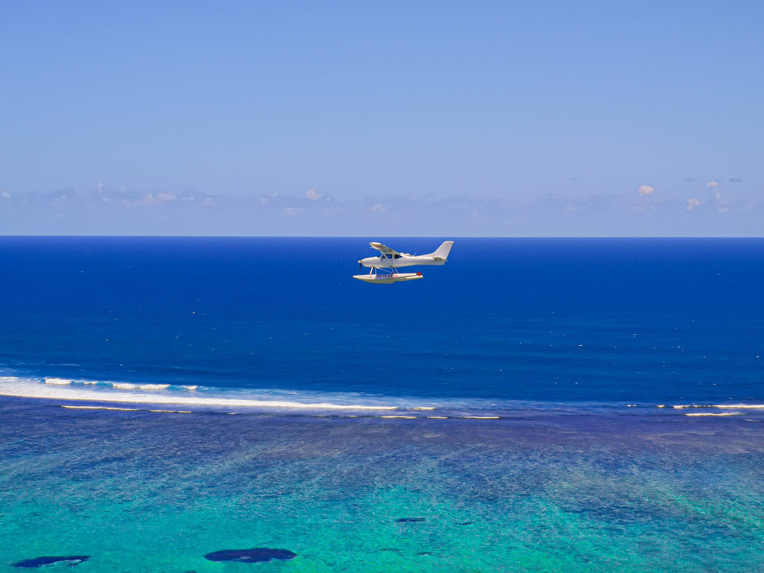 A seaplane over a blue lagoon of Mauritius
