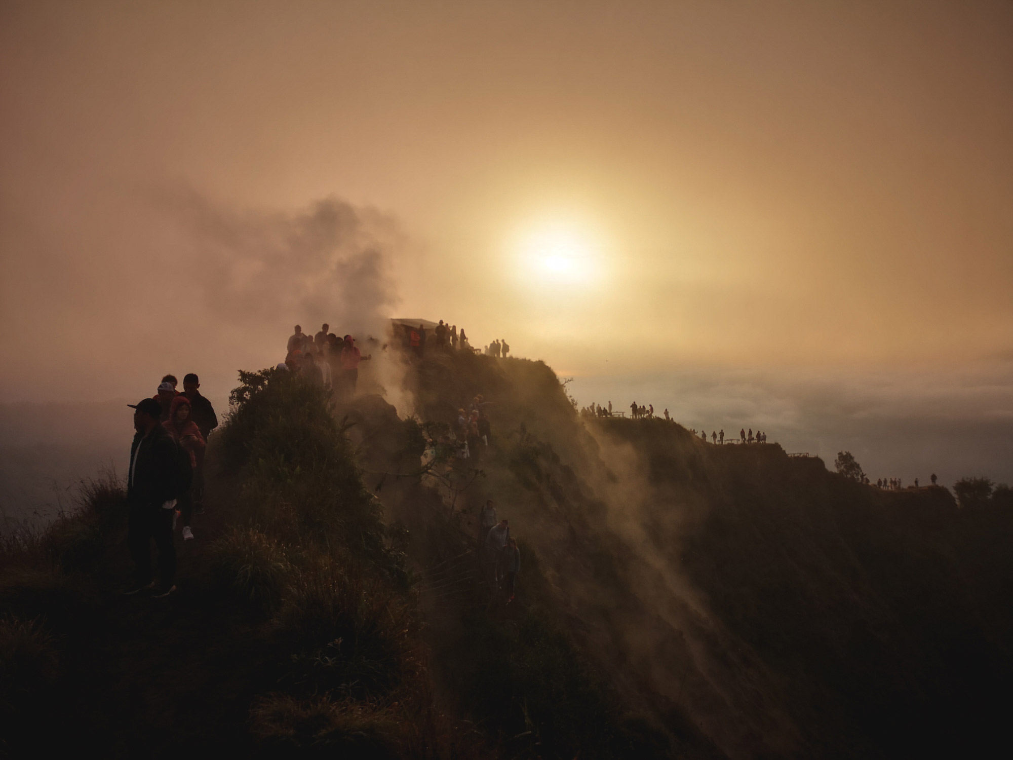 People hiking on the edge of Mount Batur caldera
